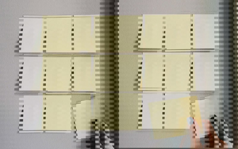 Nine sticky notes stuck to the wall in a grid