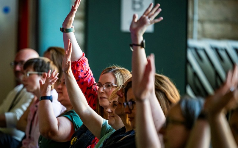 A row of people with their hands raised