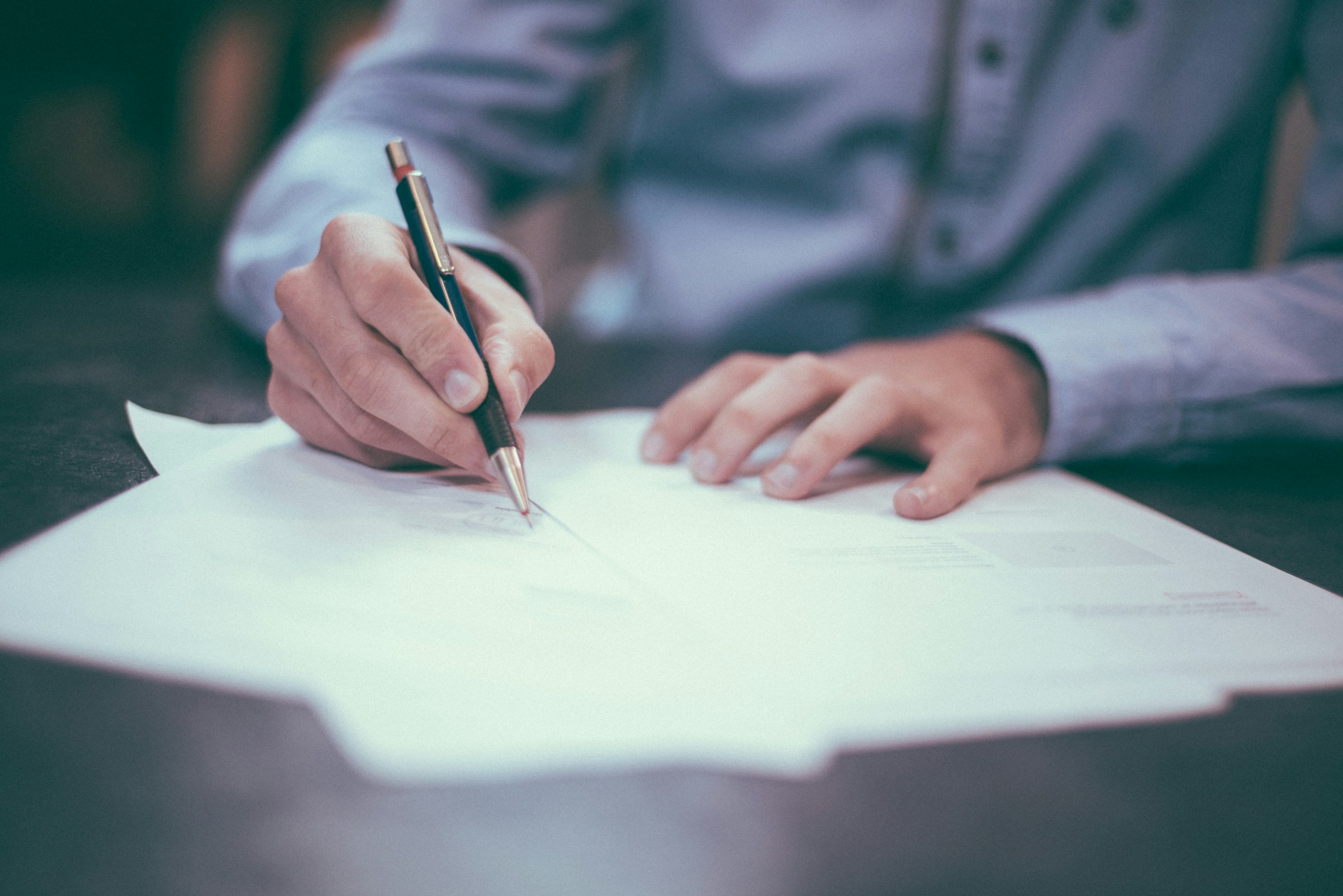 Close up photo of a person signing a document