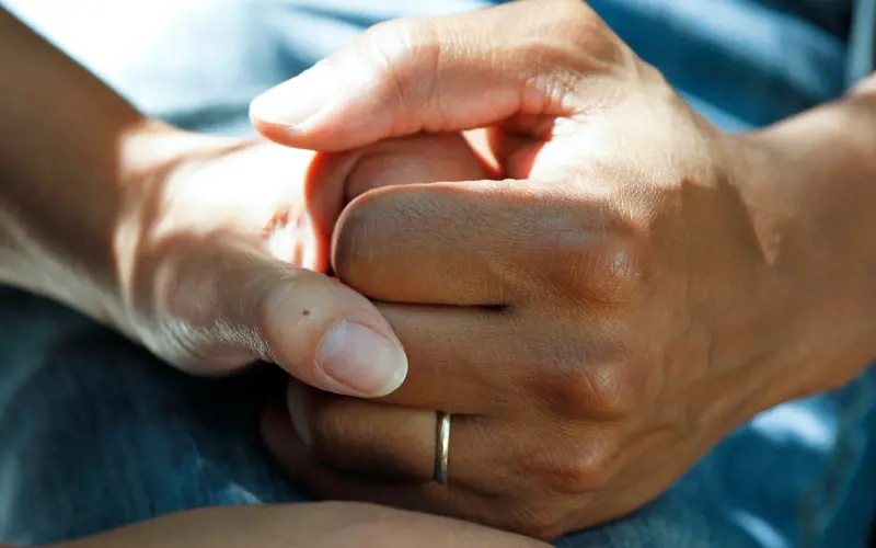 A close-up of two people holding hands