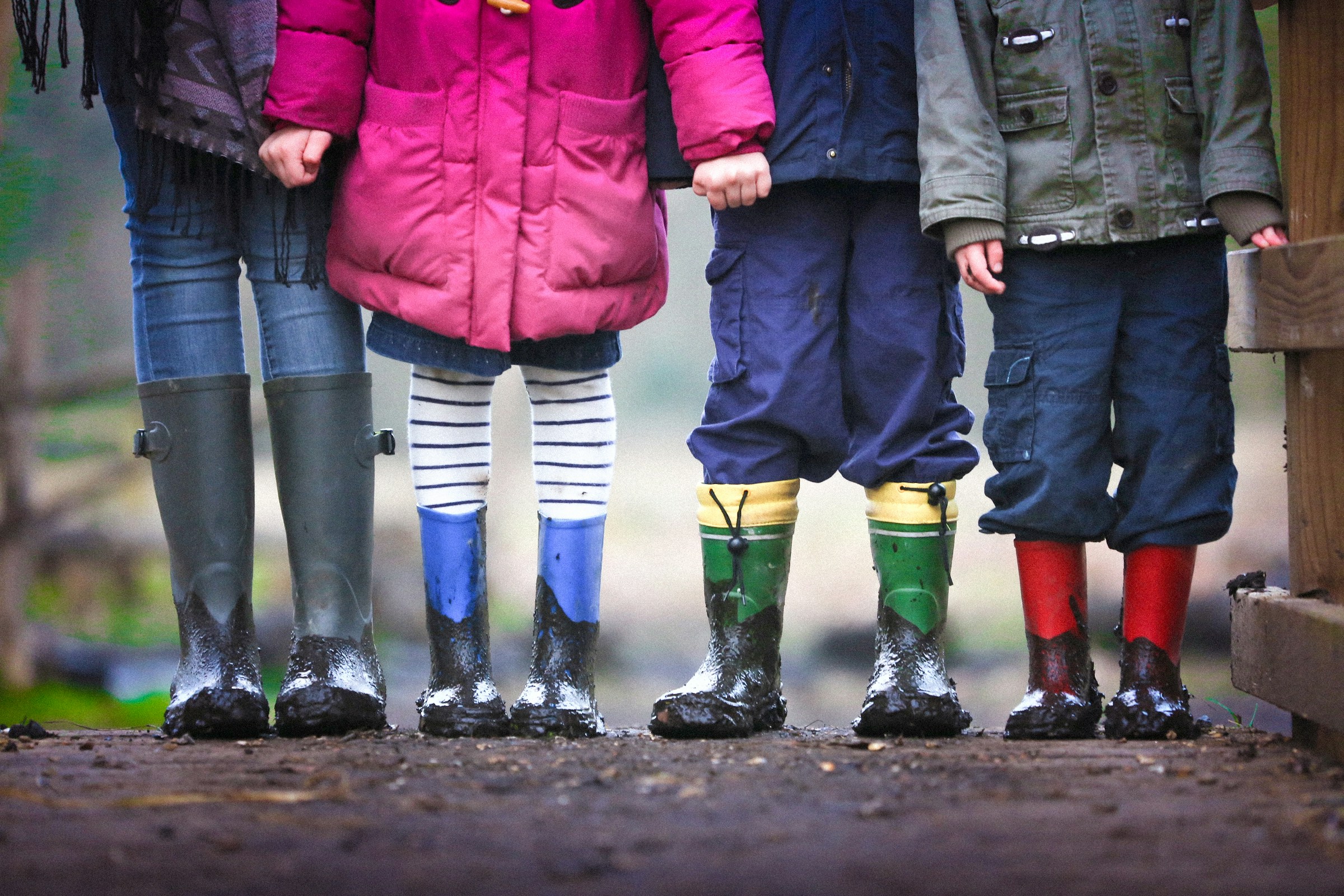 Four children wearing muddy boots