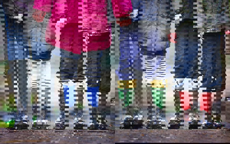 Four children wearing muddy boots