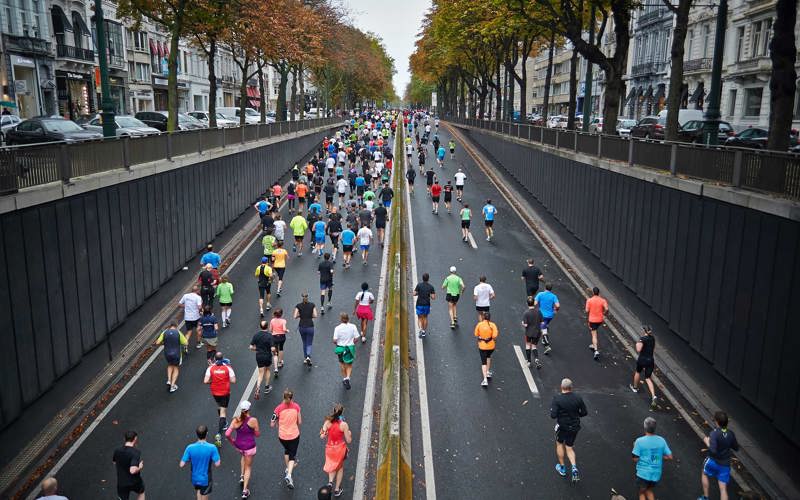 Many runners in colourful tops on a closed city street