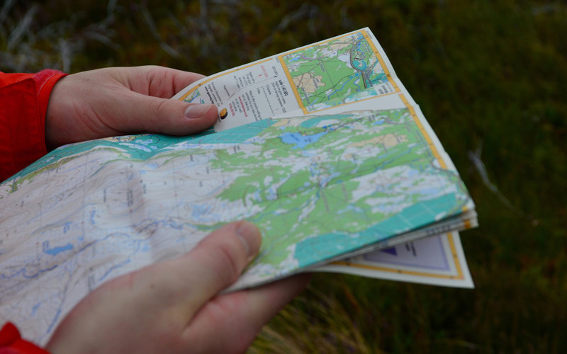 Two hands holding a map of the hills.