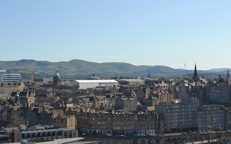 Cityscape of old town Edinburgh with hills in the distance 