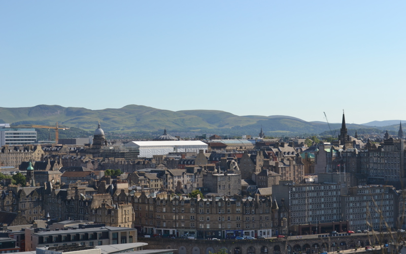 Cityscape of old town Edinburgh with hills in the distance 