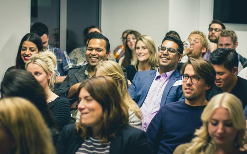 Smiling audience members in a conference session