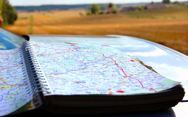 Roadmap in the foreground with a landscape of brown fields in the background
